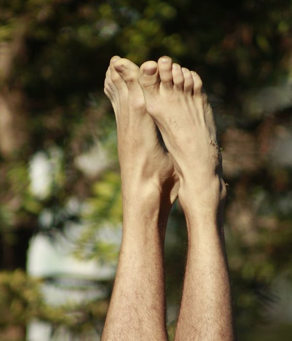 Person in a calm yoga pose outdoors with nature background.